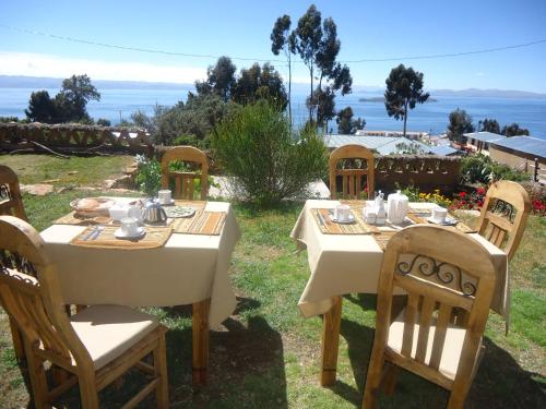a table and chairs with a view of the ocean at Hostal del Sol Isla del Sol in Isla de Sol