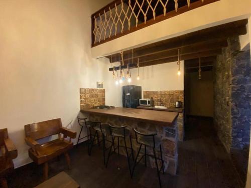 uma cozinha com um bar com bancos e uma mesa em Cabañas MiNa's em Huasca de Ocampo