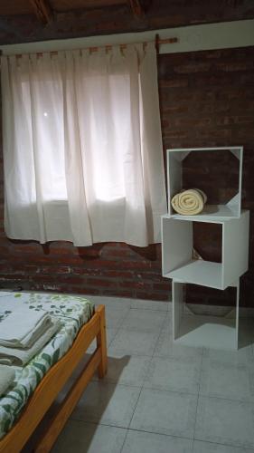 a bedroom with a window and a bed and a shelf at Cabaña Rayen in Esquel