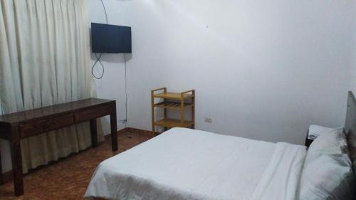 1 dormitorio con cama, mesa y escritorio en La Farola Cajamarca, en Cajamarca