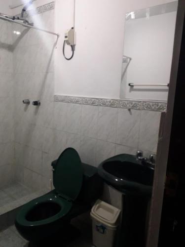 a bathroom with a green toilet and a sink at La Farola Cajamarca in Cajamarca