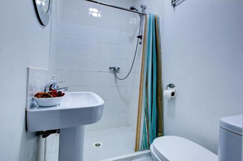 a white bathroom with a sink and a shower at OAT Homes in London