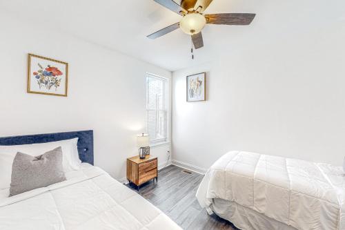 a white bedroom with a bed and a ceiling fan at Brixton Manor in Baltimore