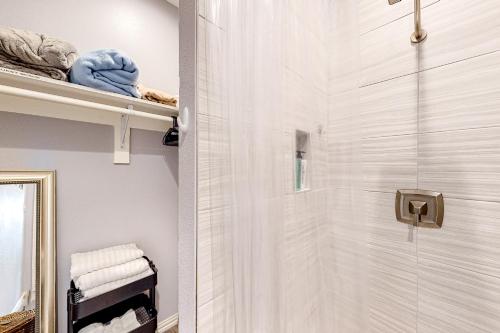 uma casa de banho com um chuveiro e uma porta de vidro em Pura Vida Texoma, Unit A 