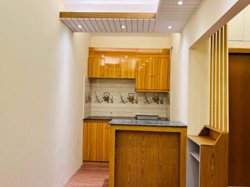 a kitchen with wooden cabinets and a ceiling at Taj Metro in Maulvi Bāzār