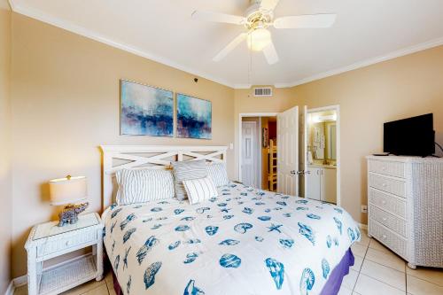 a bedroom with a bed and a ceiling fan at Tradewinds #1208 in Orange Beach