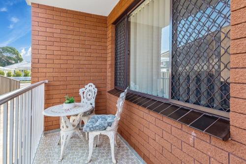 a patio with two chairs and a table on a balcony at Pepe's Beach Pad in Towradgi