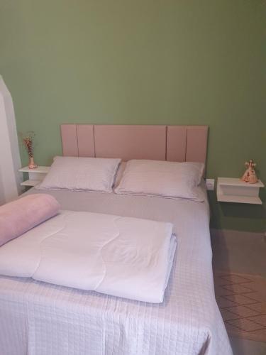 a bedroom with two beds with white sheets at Suíte privativa confortável in Diamantina