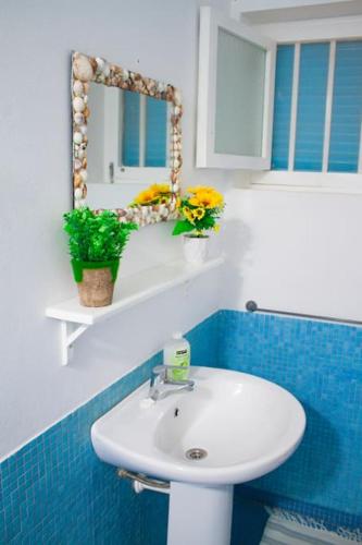 a bathroom with a white sink and a mirror at Relaxing Blue Flat near beach! in Calheta Do Maio