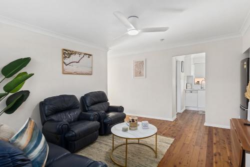 a living room with a couch and a table at Pepe's Beach Pad in Towradgi
