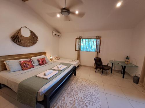 um quarto com uma cama, uma mesa e uma cadeira em Casa Mapache em Tamarindo
