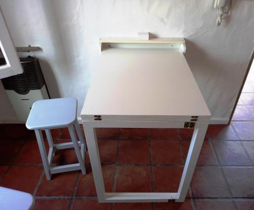 einen weißen Schreibtisch mit einem Stuhl neben einer Wand in der Unterkunft Departamento 1º P, 2 personas, WIFI, confortable, mucha luz natural in Godoy Cruz
