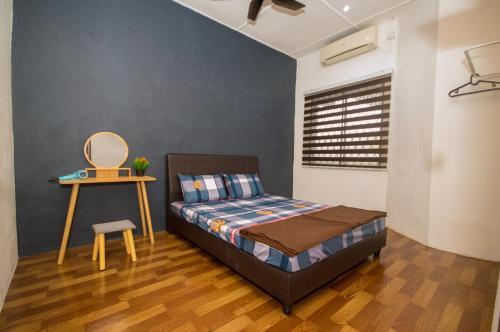 a bedroom with a bed and a table and a chair at WY Impian Homestay in Bukit Mertajam