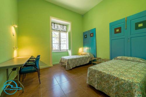 a room with two beds and a desk and a table at La Violeta Home in Puerto de la Cruz