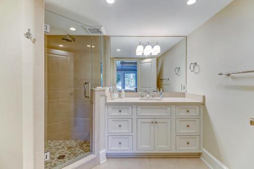 a white bathroom with a shower and a sink at Captains Court 1019 in Fernandina Beach