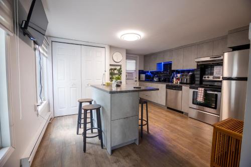 a kitchen with a counter and some stools in it at Condo in St-Roch Downtown Quebec City in Quebec City
