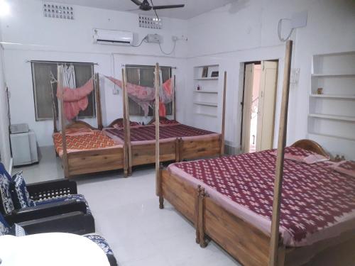 a bedroom with three beds with hammocks in it at Sudha Kutir Puri in Puri