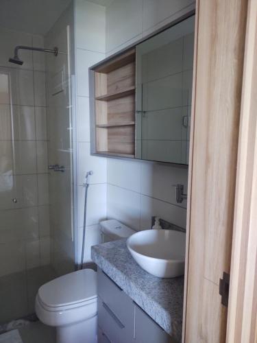 a bathroom with a sink and a toilet and a mirror at Beach Class Ilha do Leite 3105 in Recife