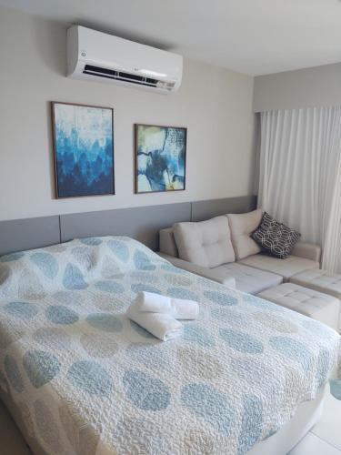 a white bedroom with a bed and a couch at Beach Class Ilha do Leite 3105 in Recife