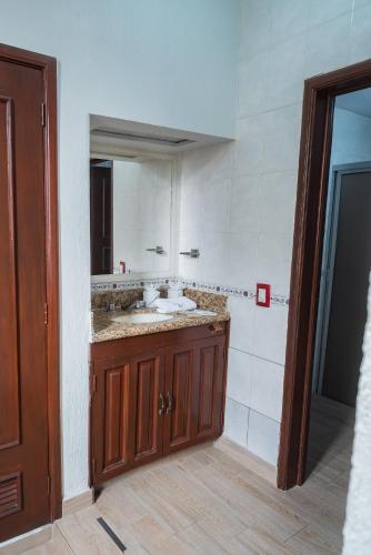 a bathroom with a sink and a mirror at Hotel Don Quijote Plaza - Guadalajara Centro Historico in Guadalajara