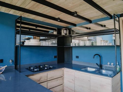 cocina con paredes azules y techos de madera en VOLARE Experience en Guatapé