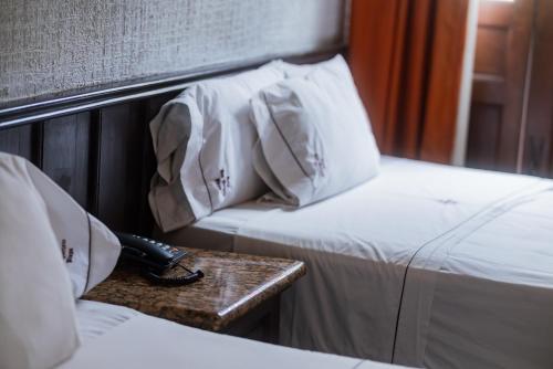 a room with two beds and a phone on a table at Hotel Don Quijote Plaza - Guadalajara Centro Historico in Guadalajara
