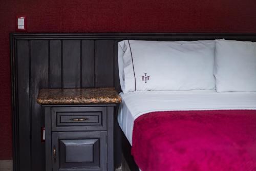 a bedroom with a bed and a nightstand next to a bed sidx sidx sidx at Hotel Don Quijote Plaza - Guadalajara Centro Historico in Guadalajara