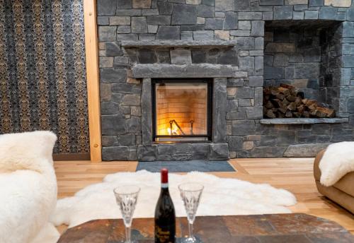 a living room with a fireplace with a bottle of wine at Romantic Luxury Retreat with Private Sauna & Spa, Pet Friendly, Elkside Hideout B&B in Canmore