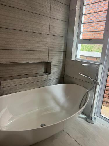 a white bath tub in a bathroom with a window at Villa Le Rosa Unit 3 in Durban