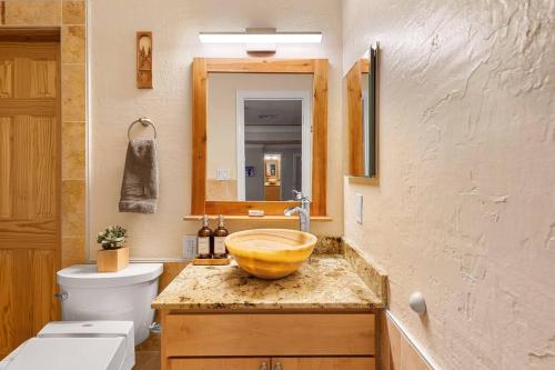 a bathroom with a sink with a wooden bowl at The Hummingbird House, Sauna & Mountain Views! in Phoenix