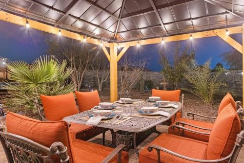 a table and chairs on a patio with an umbrella at The Hummingbird House, Sauna & Mountain Views! in Phoenix