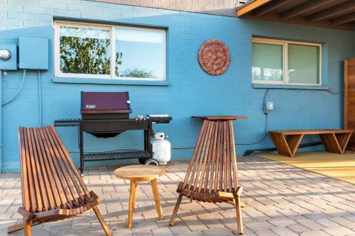 a blue wall with two chairs and a piano at The Hummingbird House, Sauna & Mountain Views! in Phoenix