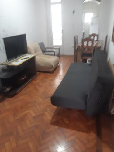 sala de estar con sofá y TV en Apartamento Arouche, en São Paulo