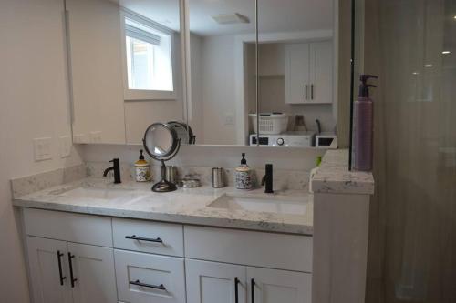 a white bathroom with a sink and a mirror at Cozy 1 BR Apartment in NW Seattle w/ Private Patio in Seattle