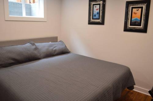 a bed in a bedroom with two pictures on the wall at Cozy 1 BR Apartment in NW Seattle w/ Private Patio in Seattle