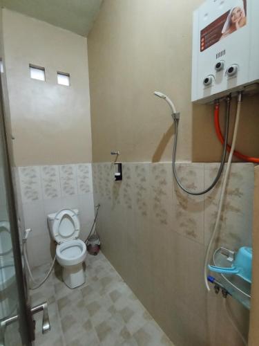 a bathroom with a toilet and a shower at Villa Lilly in Batu