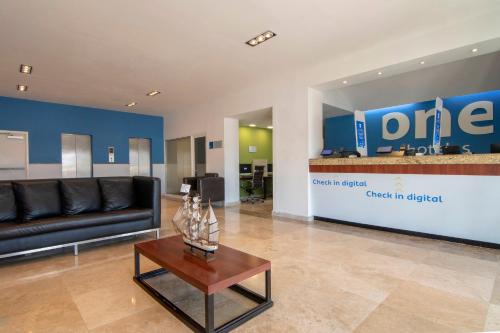 a living room with a couch and a table at One Coatzacoalcos Forum in Coatzacoalcos