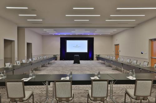 a large room with tables and chairs and a screen at InterContinental At Doral Miami by IHG in Miami