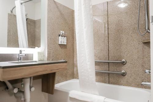 uma casa de banho com um lavatório, uma banheira e um chuveiro em Candlewood Suites Richmond Airport, an IHG Hotel em Sandston