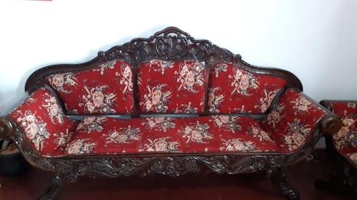 a red couch sitting in a living room at Rismin's Home Stay in Divulpitiya