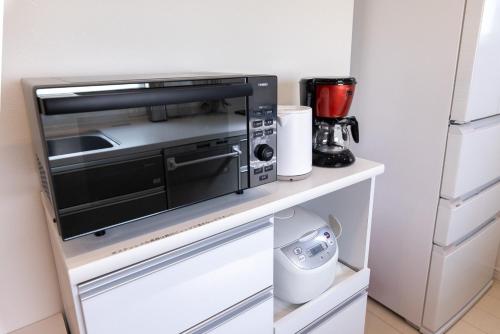 a microwave oven sitting on a counter in a kitchen at NAOX I in Miyako Island