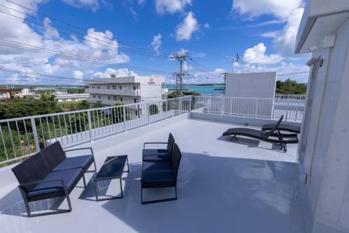a balcony with chairs and a view of the ocean at NAOX I in Miyako Island