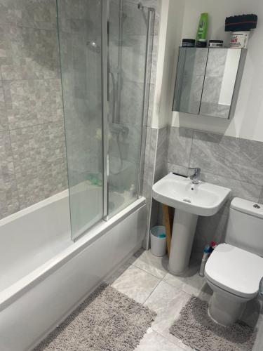 uma casa de banho com um chuveiro, um WC e um lavatório. em Cottage house em Northampton