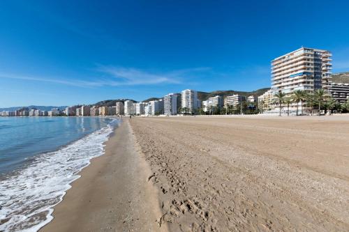 een uitzicht op een strand met gebouwen op de achtergrond bij Beach Apartment in Cullera in Cullera