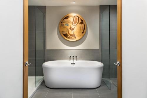 a bathroom with a white tub and a painting on the wall at Kwa'lilas Hotel in Port Hardy