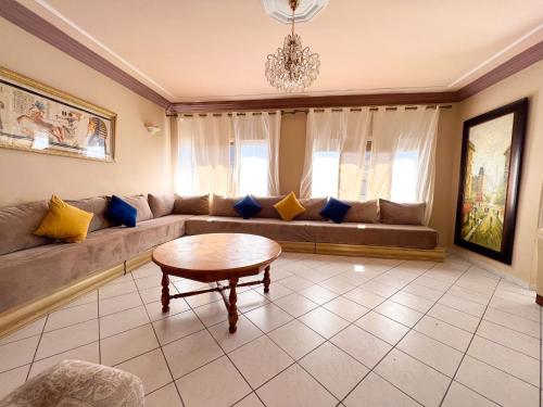 uma sala de estar com um sofá e uma mesa em Appartement en plein centre ville em Kenitra