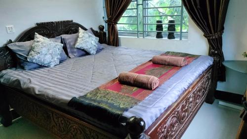 a bed with two pillows on top of it at La maison de Soriya - Work & Stay in Kampot