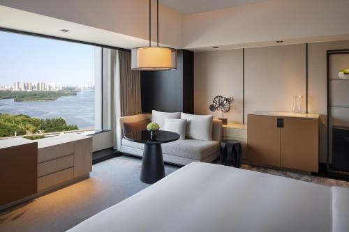 een woonkamer met uitzicht op het water bij New World Shenyang Hotel in Shenyang
