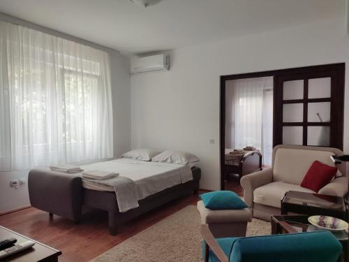 1 dormitorio con 1 cama, 1 sofá y 1 silla en Apartment MILA city center-free parking en Vranje