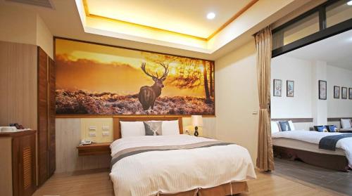 a bedroom with a bed and a painting of a deer at 逐鹿森林民宿-無電梯 in Yuchi